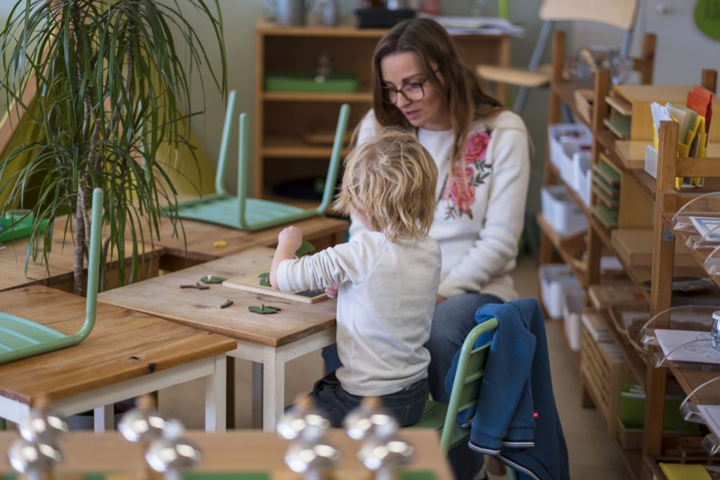 Estelle éducatrice Montessori en 3/6 ans aide un enfant en stage d'intégration à s'adapter à son nouvel environnement.