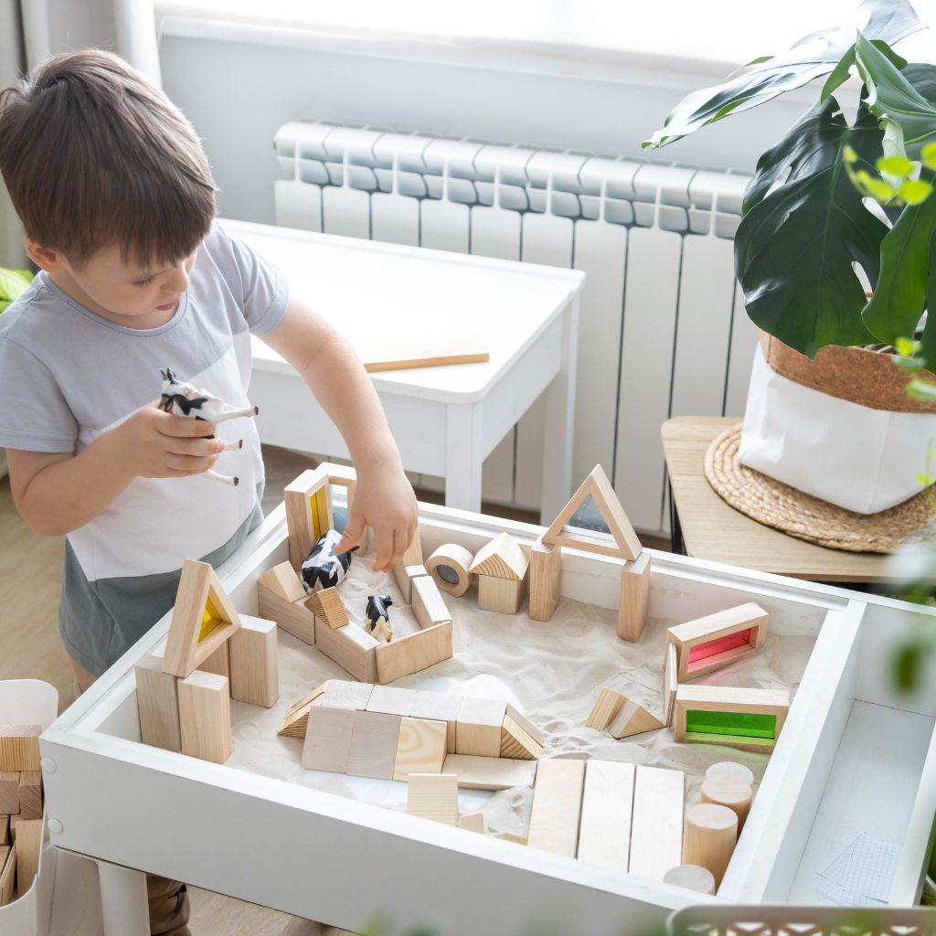 enfant qui jour avec un bac sensoriel sable chantier